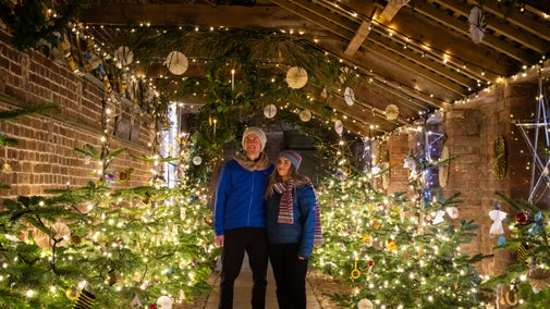 A couple looking at Christmas decorations in the ladder walk at Trelissick
